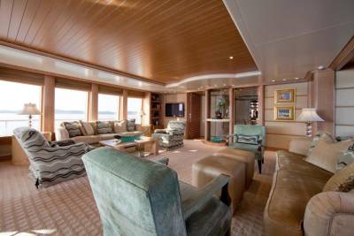Luxurious yacht interiors offer comfortable seating and ocean views through expansive windows.