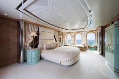 Luxurious yacht bedroom with ocean views, elegant furnishings, and a serene color palette.