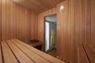Relax in the warm, woody embrace of this luxurious sauna, complete with fluffy robes for ultimate comfort.