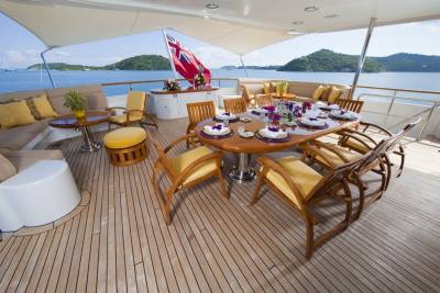 Dine al fresco on the expansive deck of this luxury yacht, surrounded by stunning ocean views and lush green islands.
