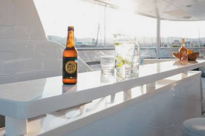 Enjoy a refreshing drink on the deck of a luxury yacht as the sun sets over the horizon.