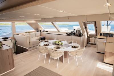 A modern yacht's dining area offers a serene setting with ocean views and elegant furnishings.