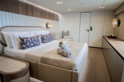 A luxurious yacht cabin features a plush bed, modern lighting, and elegant wood accents for ultimate comfort at sea.