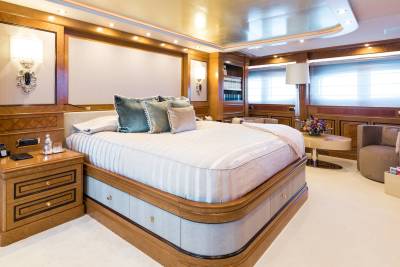 Luxurious yacht accommodations feature a plush bed, elegant wood finishes, and a serene atmosphere for ultimate relaxation.