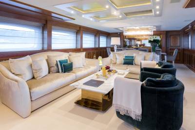 Luxurious velvet armchairs and a plush sofa create an inviting seating area within this opulent yacht salon.