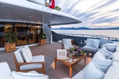 A luxurious yacht deck offers a serene setting for enjoying a sunset over the tranquil sea.