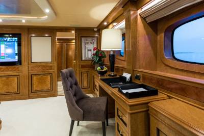 Luxurious wood paneling and a plush chair create an elegant workspace aboard this opulent yacht.