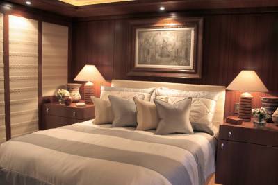 Luxurious bedroom with plush bedding, warm lighting, and elegant wooden accents creates a serene retreat.