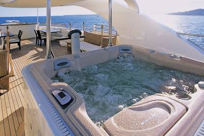 Relax in the bubbling hot tub on the deck of this luxurious yacht, surrounded by the sparkling blue sea.