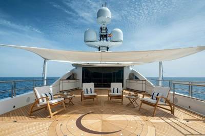Relax on the luxurious deck of a yacht, surrounded by the serene blue ocean and a clear sky.
