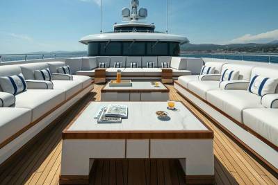 Luxurious white sofas and marble tables create an inviting outdoor lounge on this elegant yacht deck.