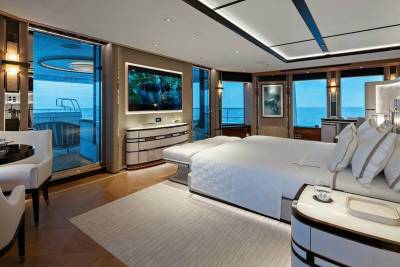 Luxurious yacht stateroom offers breathtaking ocean views from the expansive windows and private deck.
