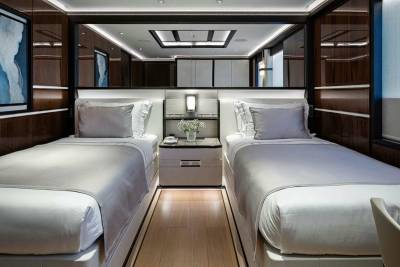 Luxurious twin beds offer a serene retreat within this elegantly appointed yacht cabin.