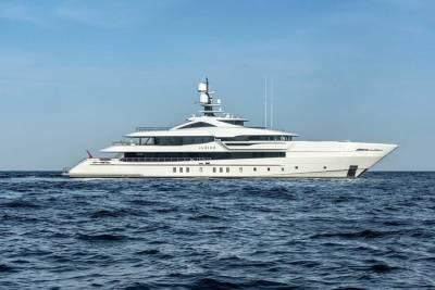 The luxurious superyacht LUSINE glides through the deep blue ocean under a clear sky.