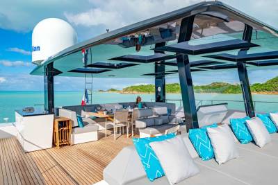 Enjoy a luxurious al fresco dining experience on the deck of this stunning yacht, surrounded by turquoise waters and lush green islands.