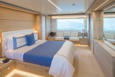 Luxurious yacht cabin offers a serene retreat with ocean views and elegant wood finishes.