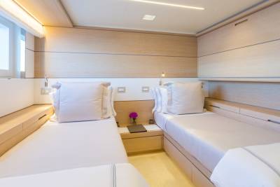 Luxurious twin beds with crisp white linens and warm wood accents create a serene retreat.