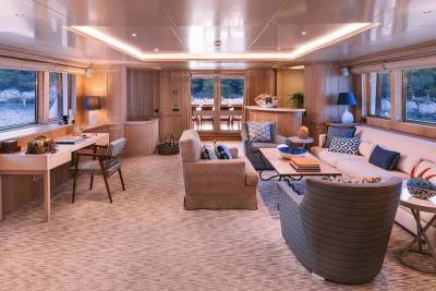 This luxurious yacht salon offers a serene ambiance with its warm wood paneling, plush seating, and stunning ocean views.