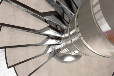 A modern spiral staircase with plush carpeted steps and polished metal accents curves elegantly upwards.