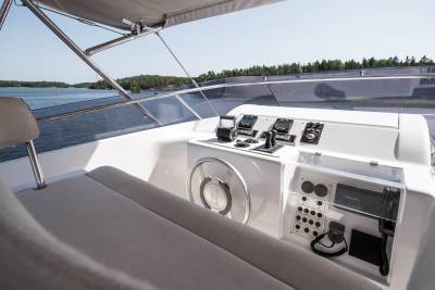Navigate the open water from the helm of this luxurious yacht, surrounded by modern controls and comfortable seating.
