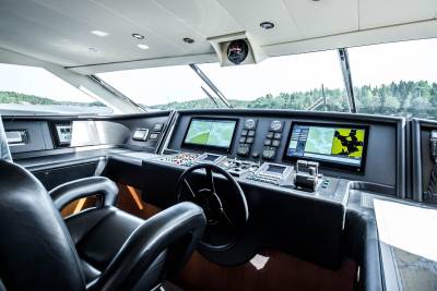 The helm of a luxury yacht offers a commanding view of the water and surrounding coastline.