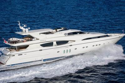 A sleek white yacht cuts through the deep blue ocean, leaving a powerful wake in its path.