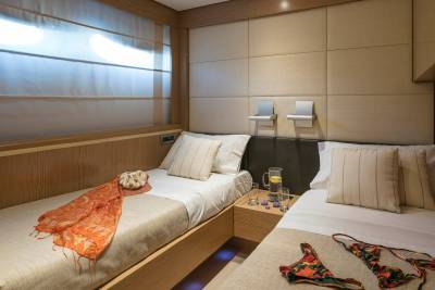Luxurious twin beds are dressed in crisp white linens and accented with stylish throws in this elegant cabin.
