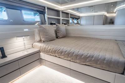 Luxurious yacht accommodations offer a serene retreat with plush bedding and ocean views through sleek porthole windows.