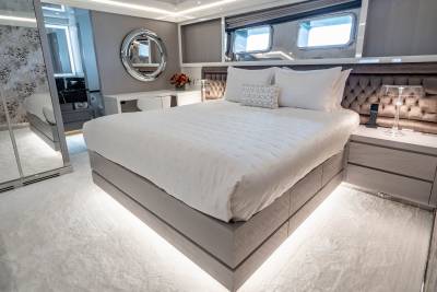 Luxurious yacht accommodations feature a plush bed, elegant decor, and ambient lighting for ultimate relaxation.