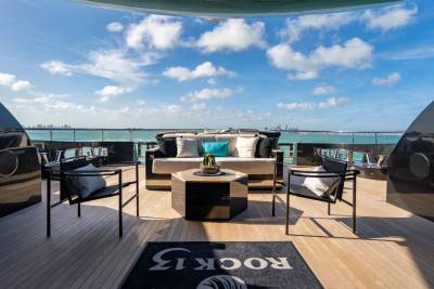 Relax on the luxurious deck of a yacht with stunning ocean views and a distant city skyline.