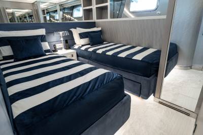 Twin beds with bold navy and white stripes offer a stylish and comfortable retreat in this yacht's cabin.