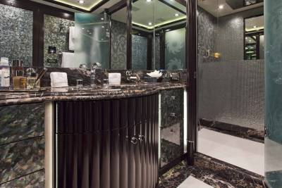 Luxurious dark wood cabinetry and marble countertops create an opulent vanity area in this sophisticated yacht bathroom.