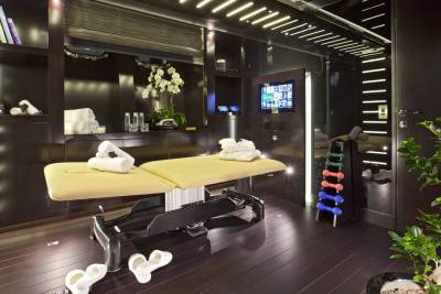 This luxurious spa room features a massage table, weights, and a serene ambiance perfect for relaxation.