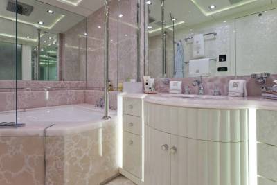Luxurious marble and elegant cabinetry create a serene and opulent bathing sanctuary.