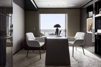 A sleek modern office with a large window overlooking the ocean offers a serene workspace.