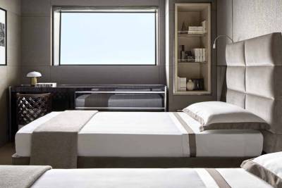 Luxurious twin beds with plush headboards and crisp white linens await in this elegantly appointed cabin.