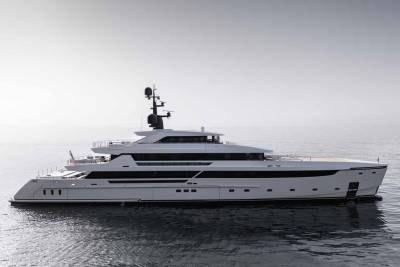 A sleek white superyacht glides serenely across calm, reflective waters under a pale, overcast sky.