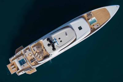 A luxurious yacht with multiple decks, a pool, and sun loungers floats serenely on the deep blue ocean.