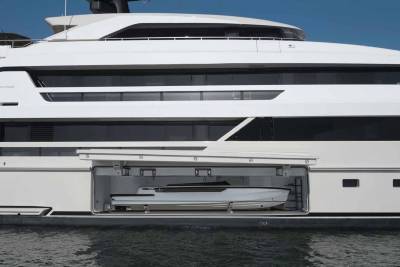 A sleek tender is stored within the hull of a luxurious white yacht, ready for its next adventure on the water.