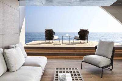 Relax on a modern outdoor lounge with a stunning view of the calm blue sea.