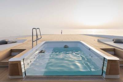 Relax in a luxurious yacht jacuzzi with a stunning ocean view at sunset.