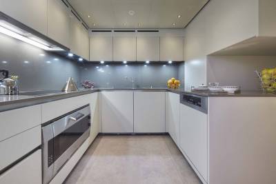 A sleek, modern kitchen with minimalist white cabinetry and integrated appliances offers a sophisticated space for culinary creations.