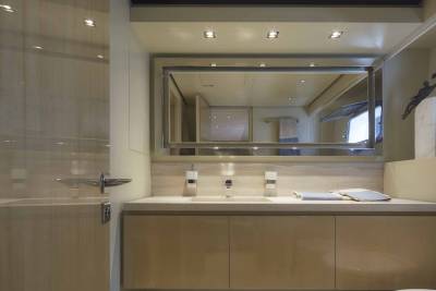 A sleek, modern bathroom vanity with a large mirror reflects the luxurious interior of a yacht.