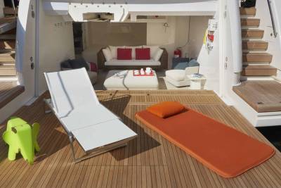 Relax on the sun-drenched deck of this luxurious yacht with comfortable seating and vibrant cushions.