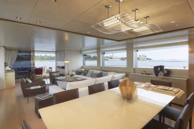 A modern yacht's spacious interior offers a comfortable lounge area with stunning ocean views and a contemporary dining space.