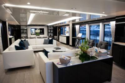 Luxurious yacht interiors offer stunning views of docked vessels through expansive windows.