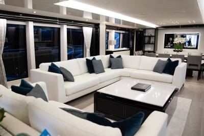 Luxurious white sectional sofas and a marble-topped coffee table create an elegant seating area on this modern yacht.