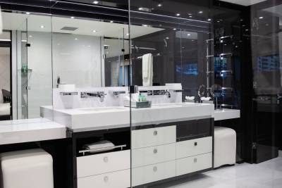 This luxurious modern bathroom features a sleek double vanity with marble countertops and a glass-enclosed shower.