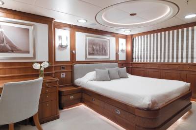 Luxurious wood paneling and elegant artwork create a serene atmosphere in this yacht's master stateroom.