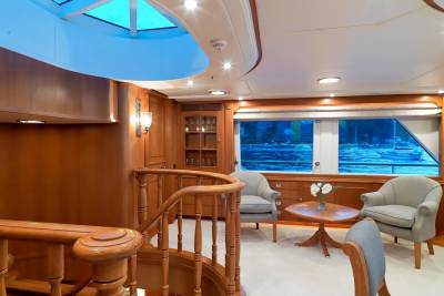 Luxurious wood paneling and plush seating create a serene atmosphere aboard this elegant yacht.